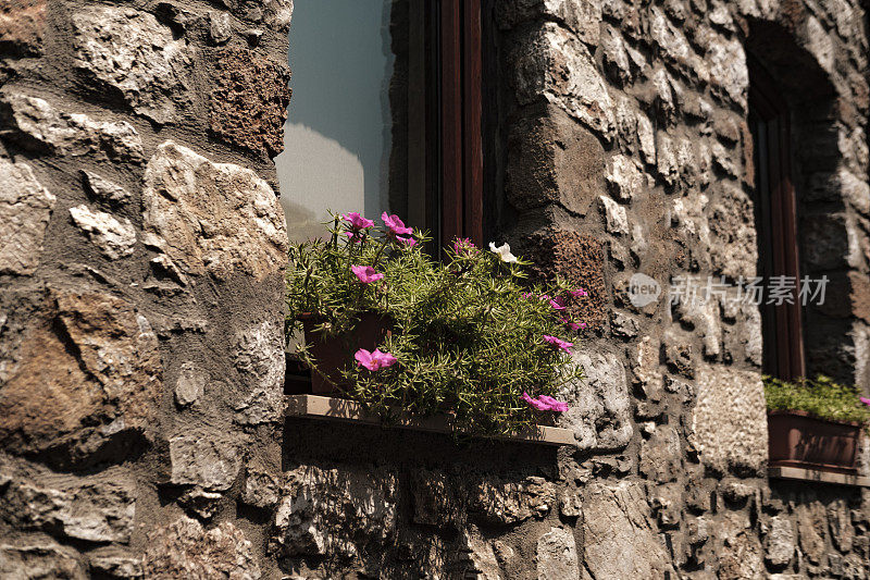 石砌拱形窗墙，花盆花，窗台上，古风建筑，现代潮流岩石纹理外饰