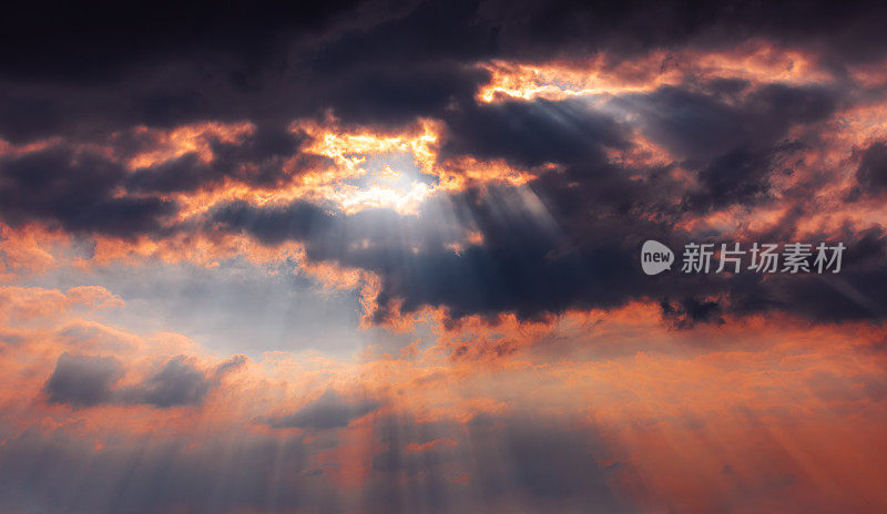 戏剧性的日落天空背景:阳光穿透黑色雷云