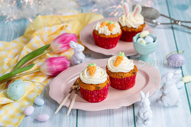 复活节纸杯蛋糕，奶油芝士糖霜，胡萝卜和兔子耳朵装饰。