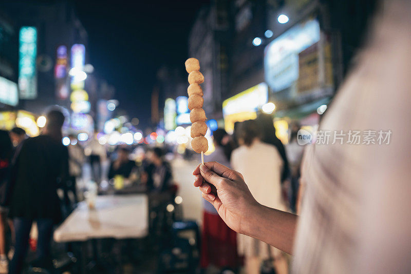 一对年轻的亚洲夫妇在台湾逛了当地著名的夜市，品尝了街头小吃