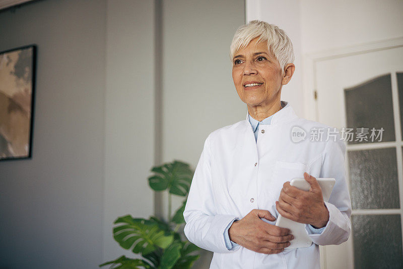 高级女医生在医疗柜里拿着数码平板电脑