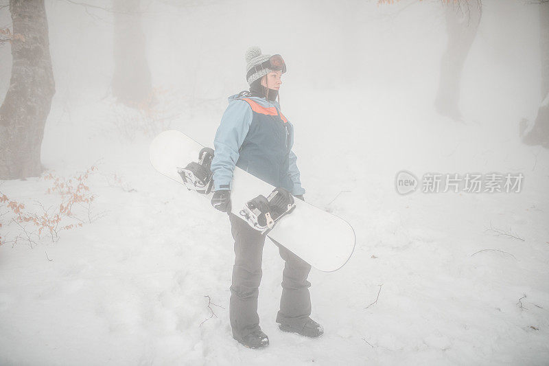 一个女人准备在山上滑雪的全貌