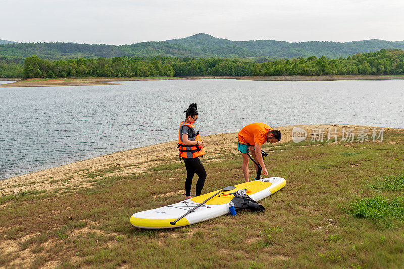 年轻人在湖边玩桨板