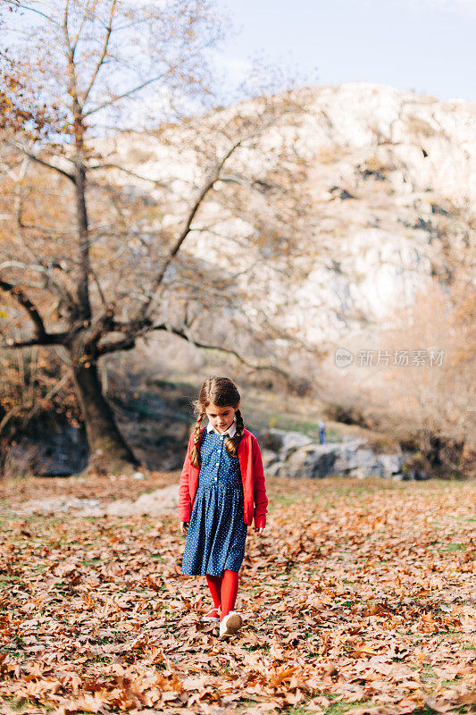 小女孩赤脚走在秋天的森林里
