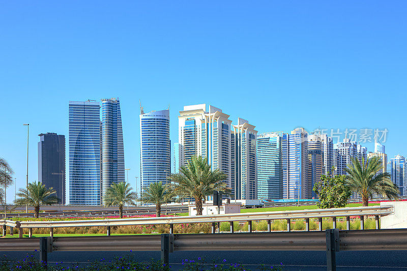 迪拜，阿拉伯联合酋长国——迪拜码头上的摩天大楼在清晨的阳光下映衬着清澈的蓝天