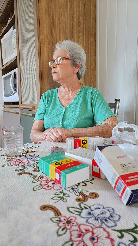 70岁白发的白人妇女，一只胳膊搁在桌子上。