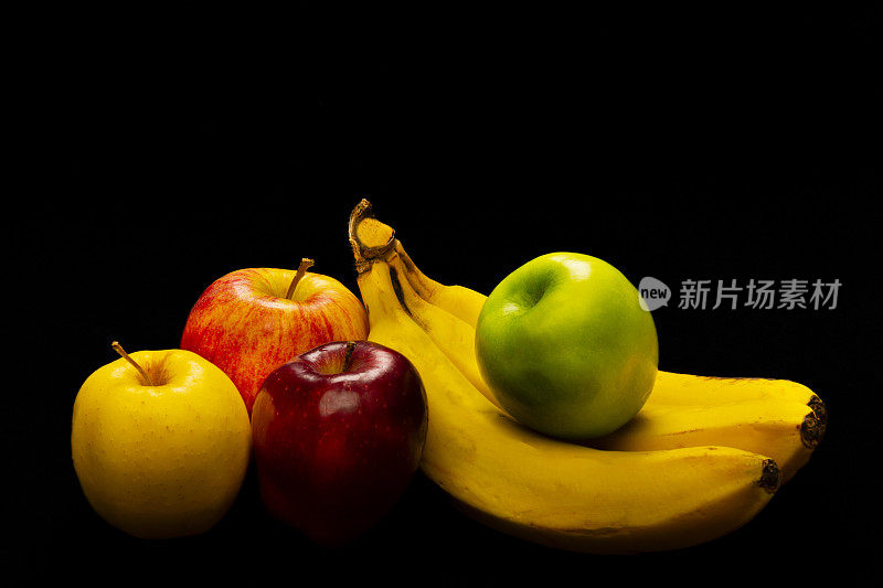 黑色背景上的一组苹果水果和香蕉