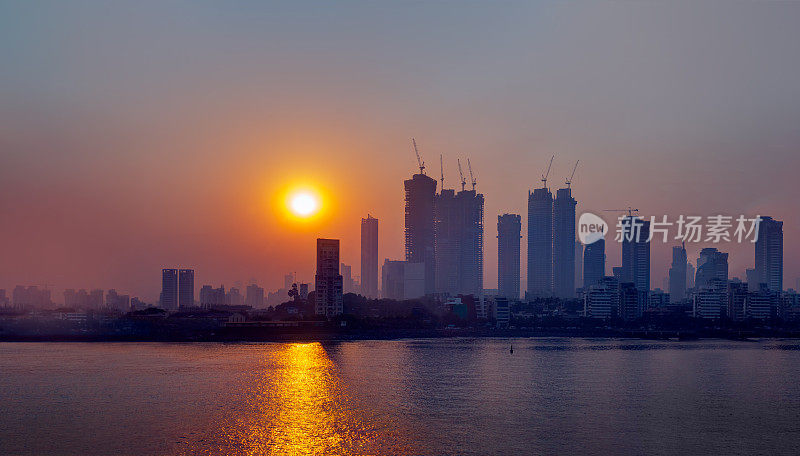 空气污染概念——日落时的现代高层建筑和贫穷的贫民窟——印度孟买