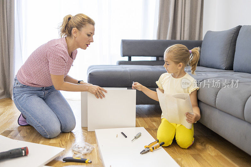 孩子在客厅里帮妈妈组装家具