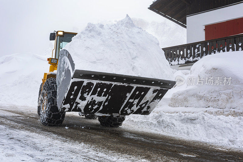 挖掘机在冬天从路上挖雪