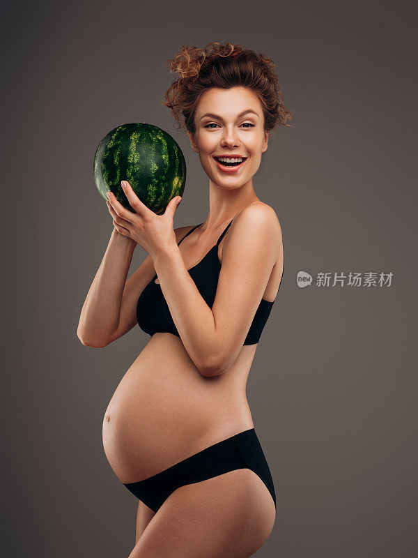 漂亮的孕妇拿着西瓜
