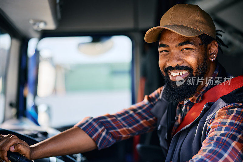 快乐的黑人职业卡车司机看着镜头。