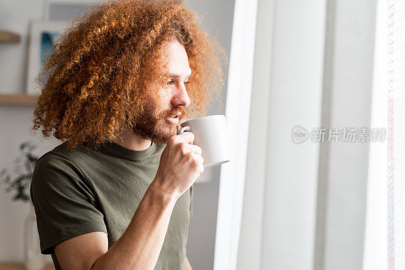 拿着咖啡杯沉思的男人