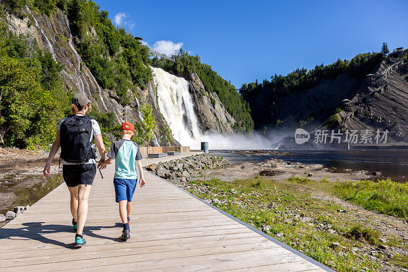 加拿大魁北克市，夏天，母亲和儿子走在蒙莫伦西瀑布的人行桥上