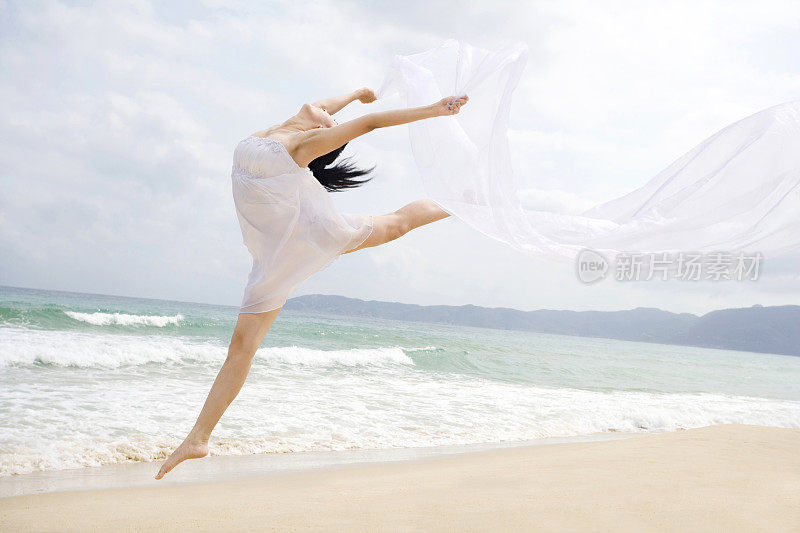 女子海边起舞飞跃