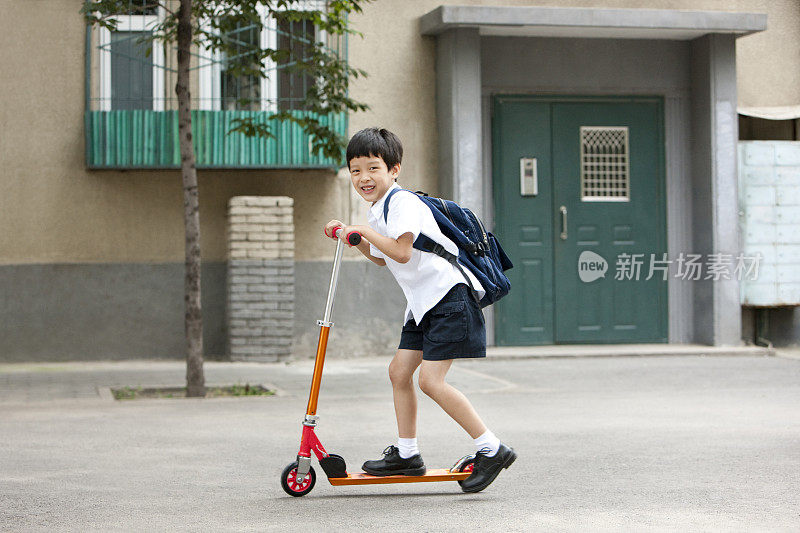 儿童在普通社区玩踏板车