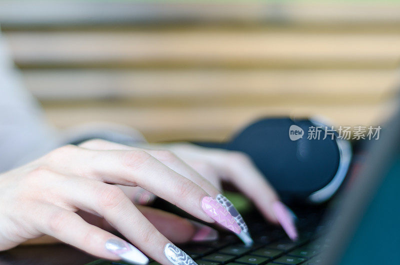 女人用长指甲敲打键盘