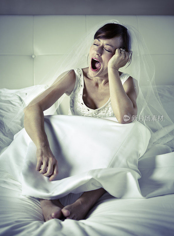 疲惫的新娘坐在床上打哈欠