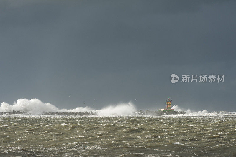 在暴风雨中非常狂暴的溅起浪花的灯塔