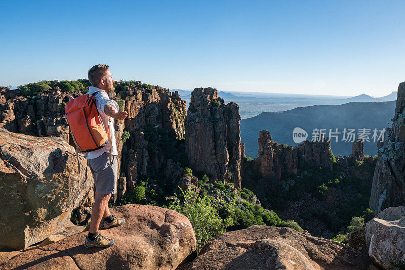 年轻人在山顶上张开双臂