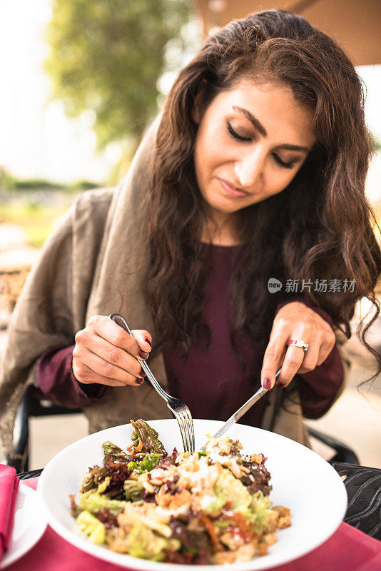 一个阿拉伯女人在餐馆吃午饭