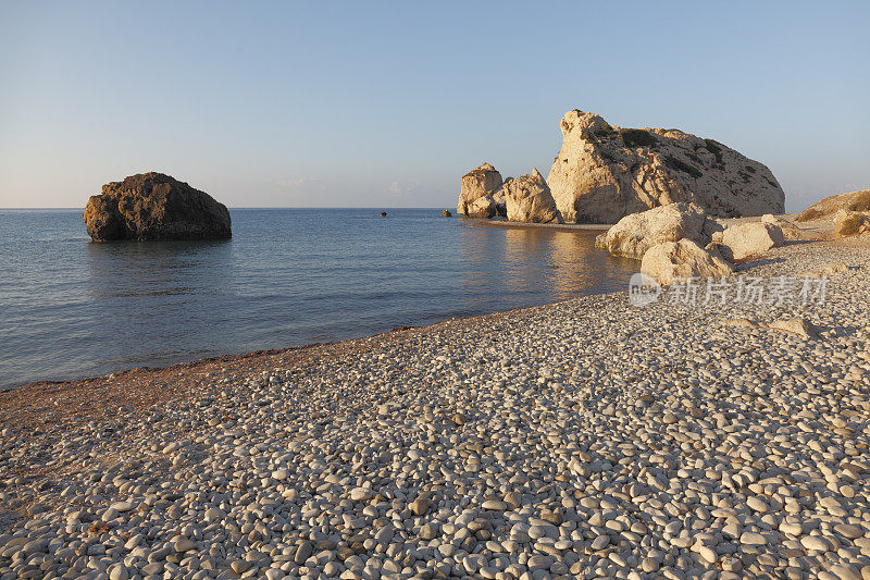 塞浦路斯阿芙罗狄蒂海滩清晨的阳光下，金色的卵石海岩石