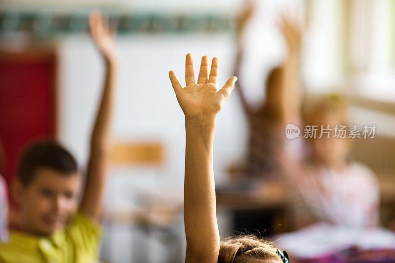 一个面目全非的女学生的手在教室里高高举起。