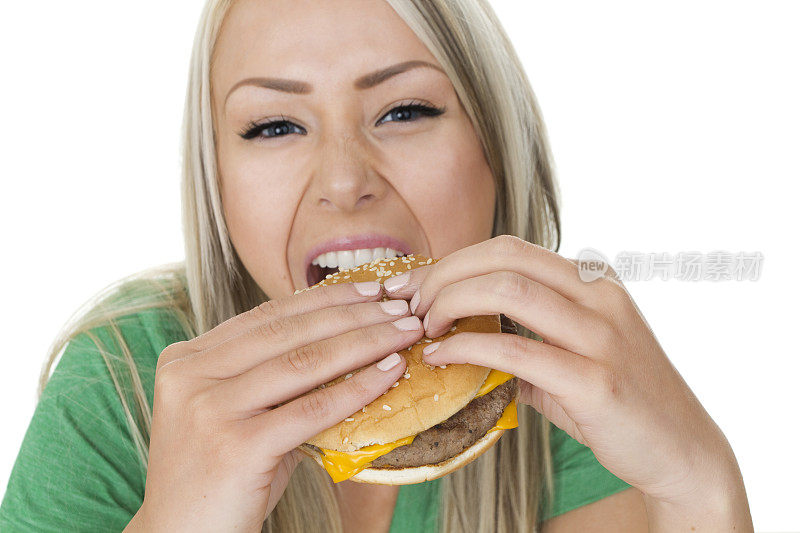 饥饿的女人在吃芝士汉堡