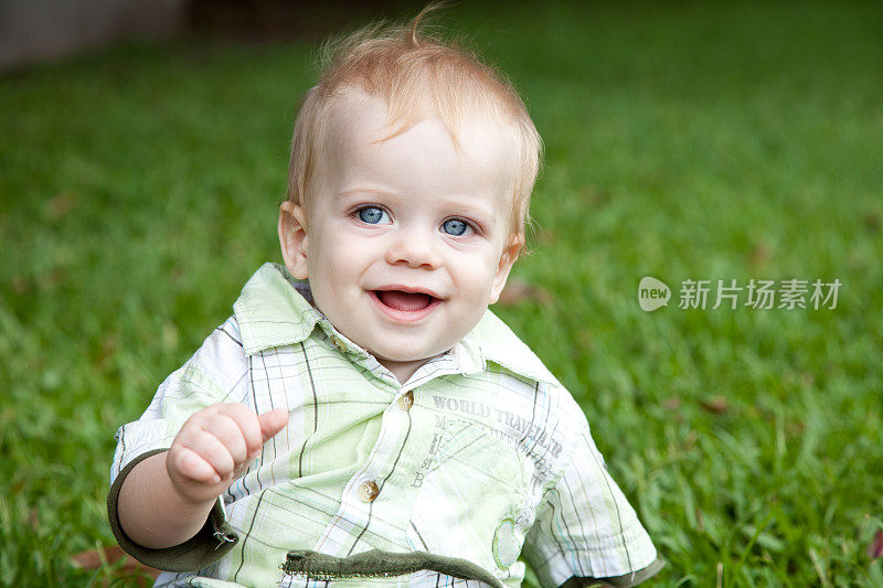漂亮的白人男婴在户外的绿草地上