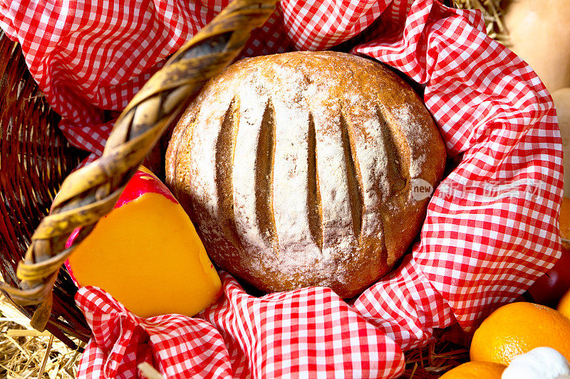 乡村野餐的配菜:柳条篮子里的黑麦面包和奶酪