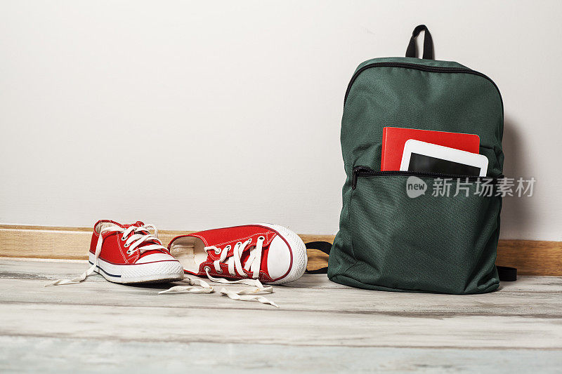 木制背景的红色运动鞋和书包