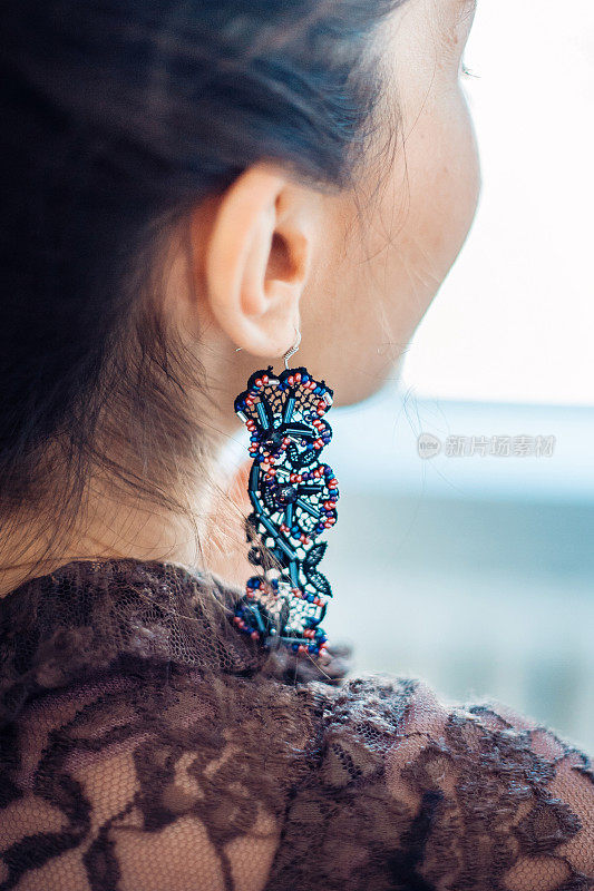 一个年轻女子的耳朵上的手工耳环。
