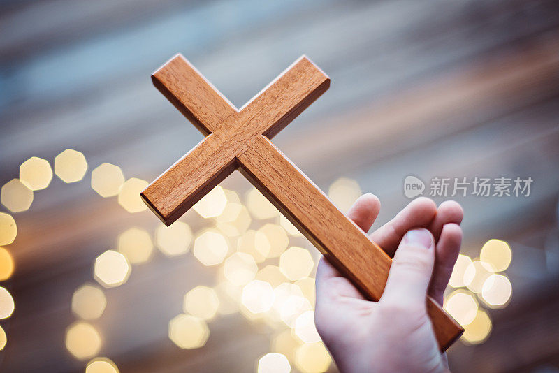 小男孩拿着木头十字架祈祷