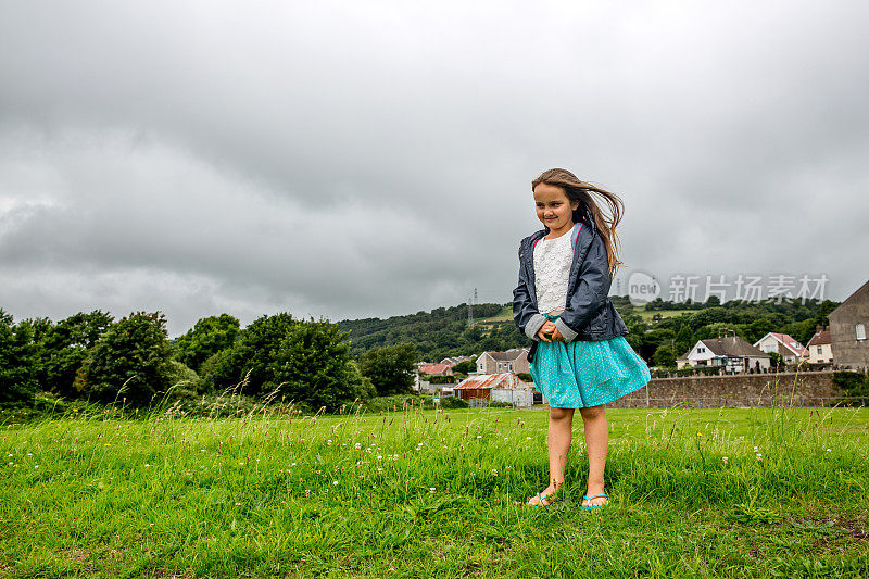 八岁的小女孩站在田野里