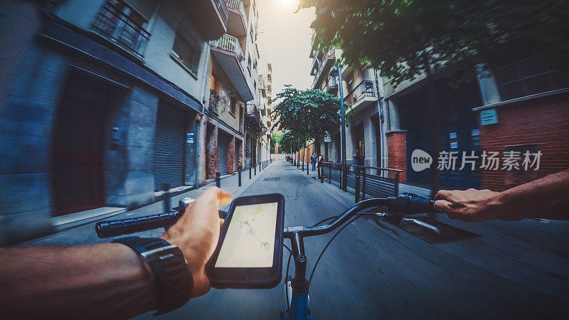 POV在城市里骑自行车，同时在手机上查阅地图
