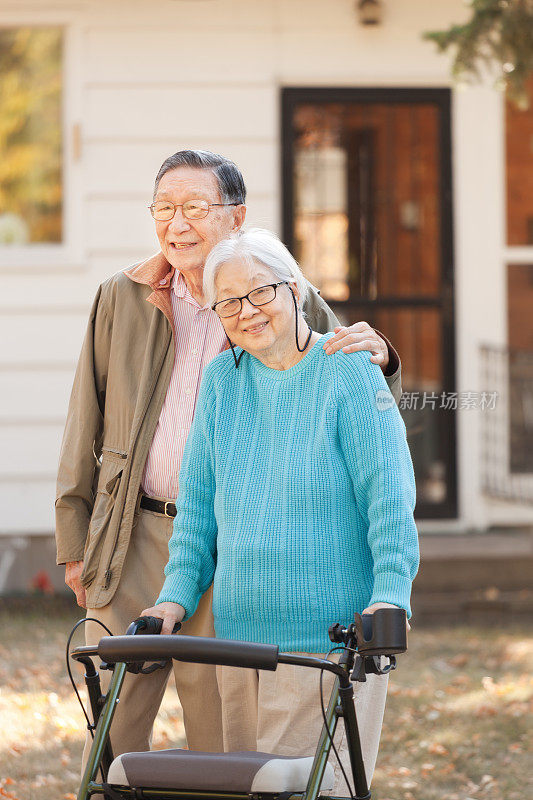 资深亚洲夫妇站在户外与沃克在秋天