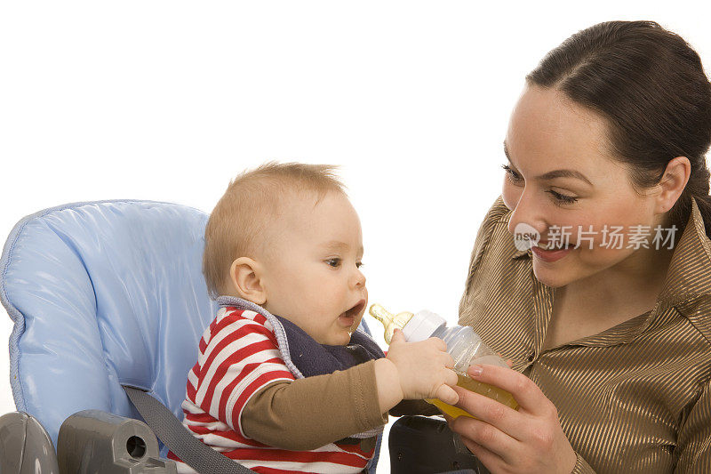 母亲正在喂一个漂亮的蹒跚学步的孩子。XXXL