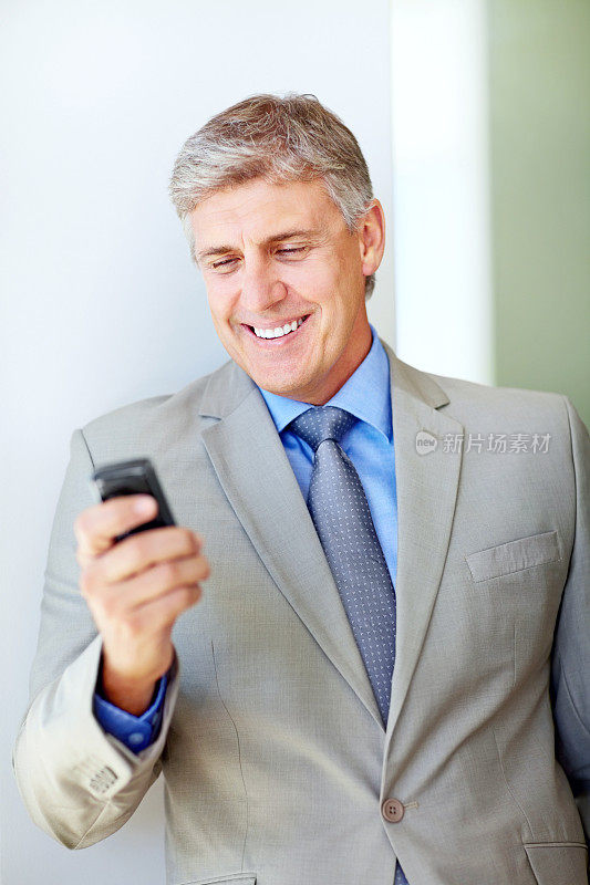 微笑着看手机短信的成熟商人