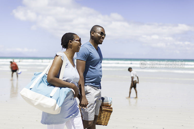 一对非洲夫妇手牵着手在海滩上散步