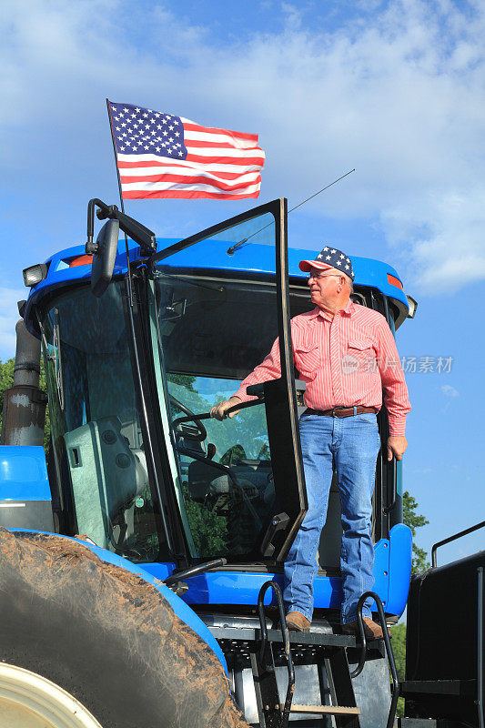 爱国的美国农民举着国旗站在拖拉机上