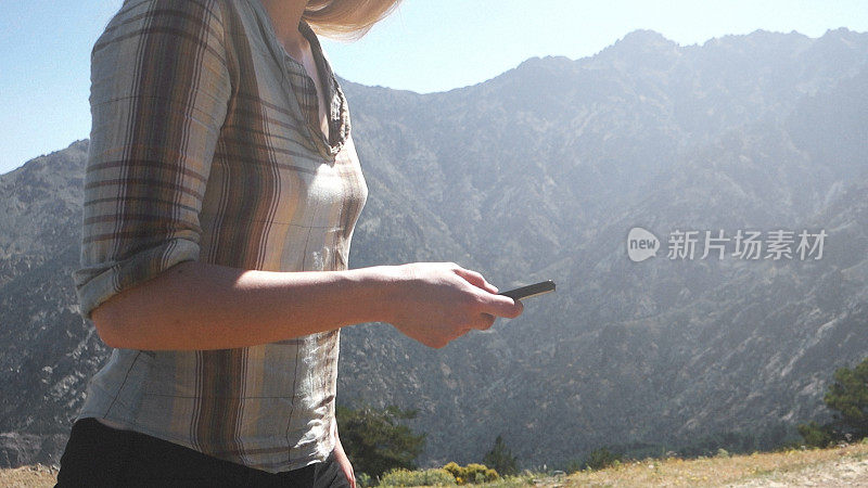 在山区使用智能手机的女人