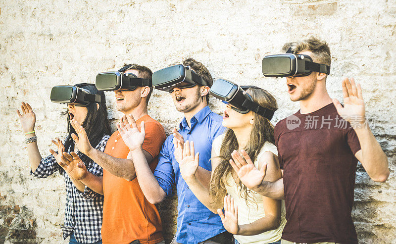 朋友群玩虚拟现实眼镜户外-虚拟现实和可穿戴的技术概念与年轻人有乐趣与耳机护目镜-数字一代趋势-复古对比滤镜