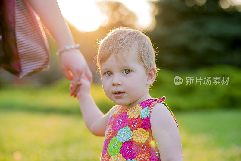 孩子和家人手牵着手，妈妈照顾宝宝