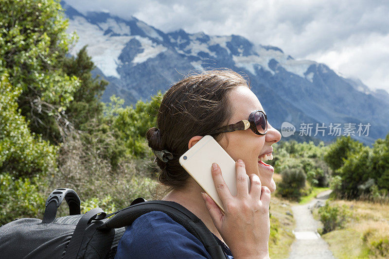 新西兰南阿尔卑斯山库克山的徒步旅行者使用智能手机