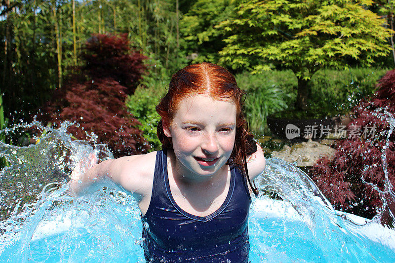 小女孩跳水的画面，在花园的水池中戏水