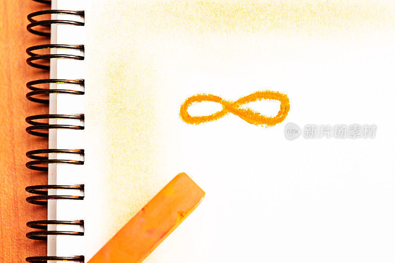 无限符号在橙色蜡笔在素描簿