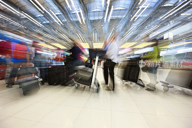 在国际机场排队办理登机手续的旅客。