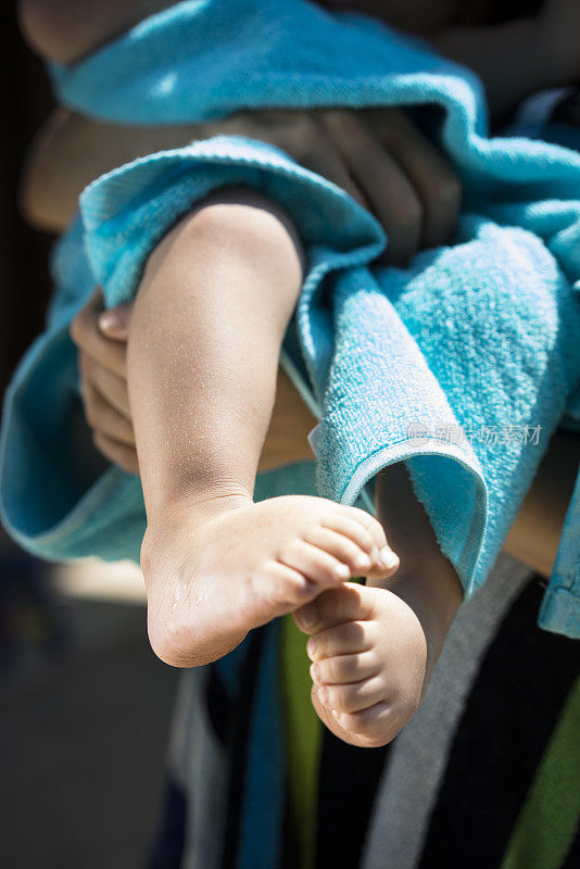 一个裹着毛巾的小孩的脚