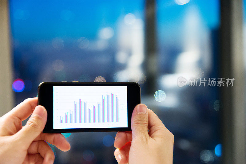 手持智能手机与业务图表-股票图像