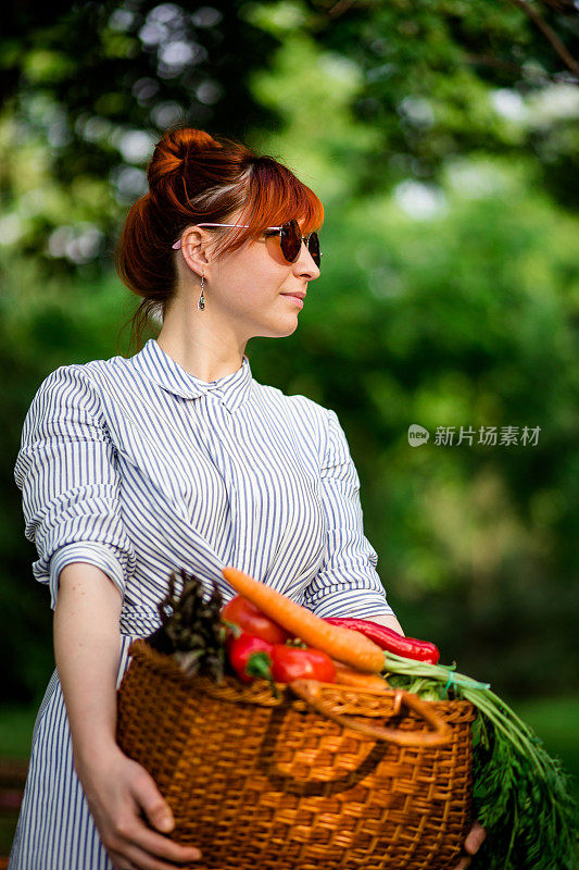 穿着一篮子蔬菜的漂亮红发女人